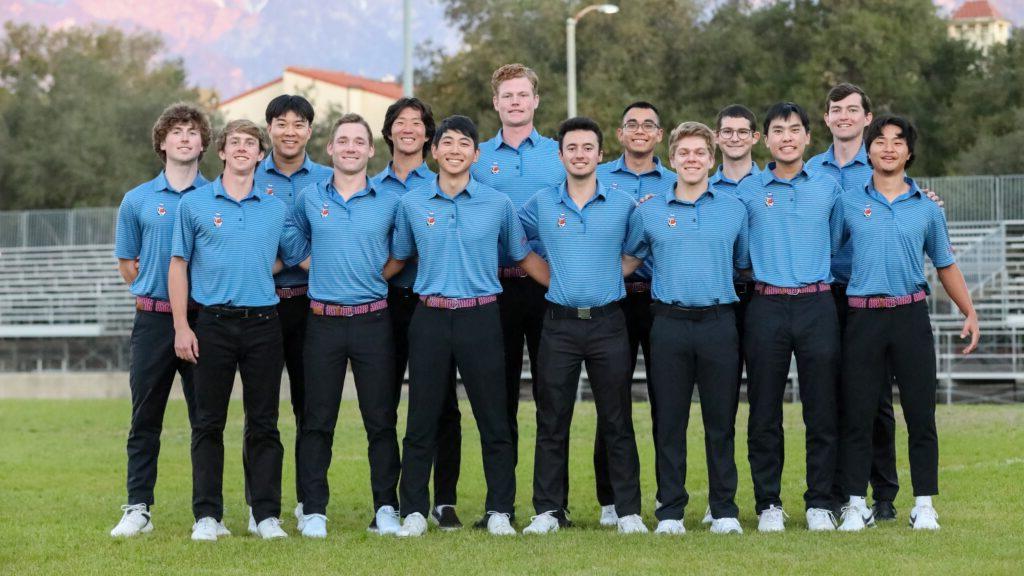 男子高尔夫球队在球场上合影. 他们穿着浅蓝色衬衫，左上角有塞西尔·萨根的小标志，制服是黑色裤子.